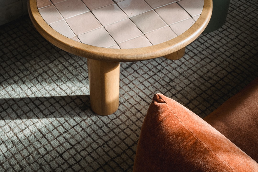 Uma Mesa De Madeira Com Tampo Trancado E Almofada Laranja nAqvVKw76mg