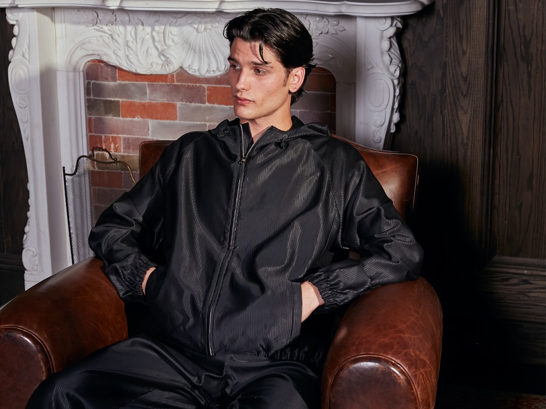 Homem De Jaqueta Preta Sentado Em Uma Poltrona De Couro 8347MaIa7Yg