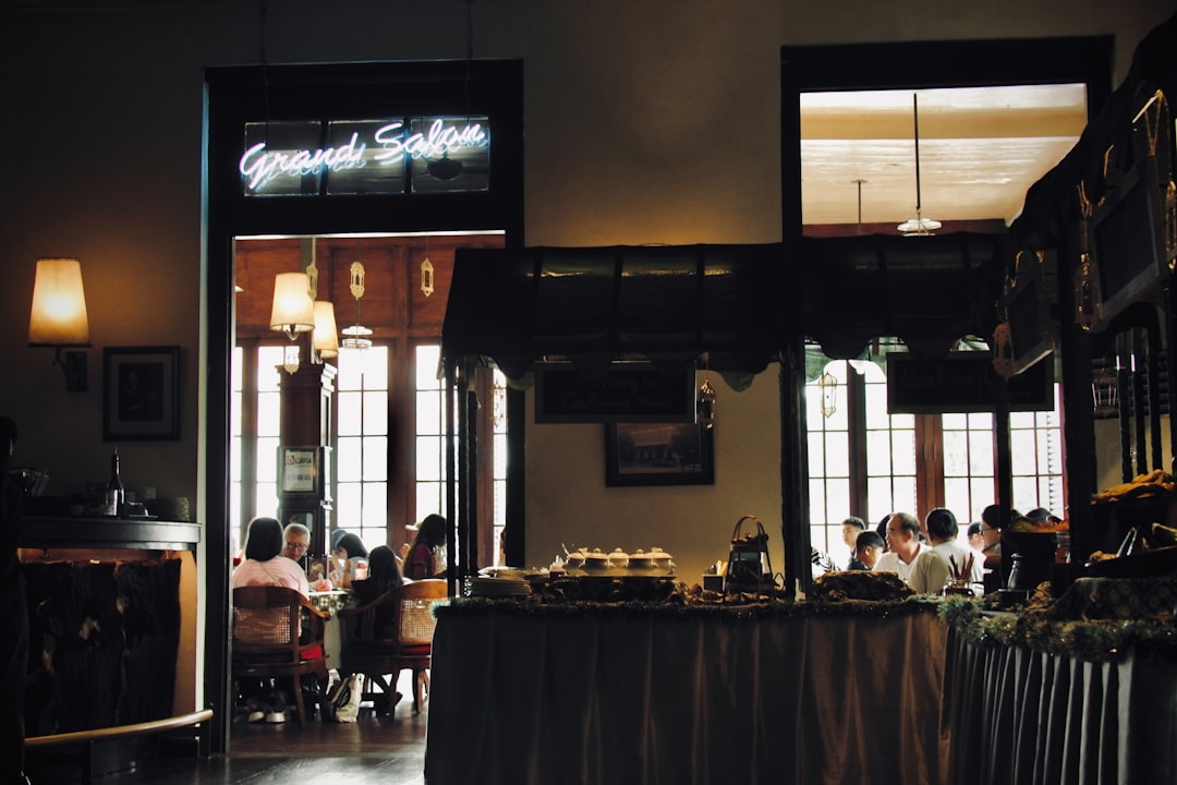 Pessoas Jantando Em Um Restaurante Pouco Iluminado Com Letreiro De Neon gqohZ5C5S8E