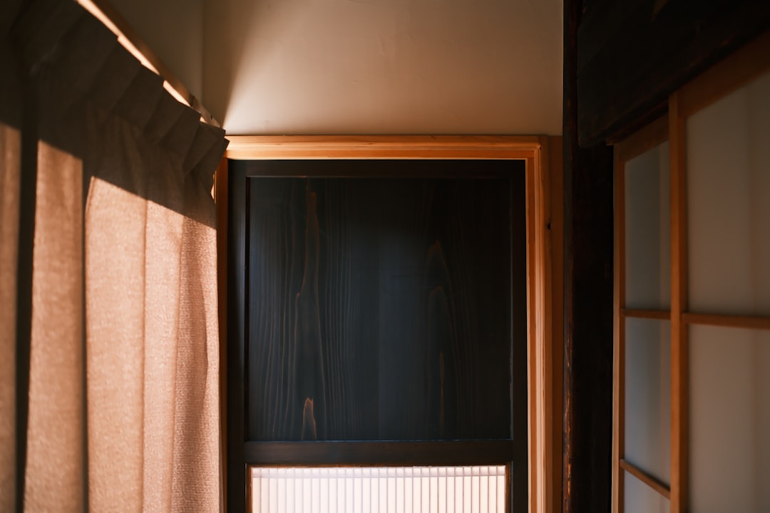 Uma Porta De Madeira Escura Com Uma Cortina Translucida uc30JmaHfdE