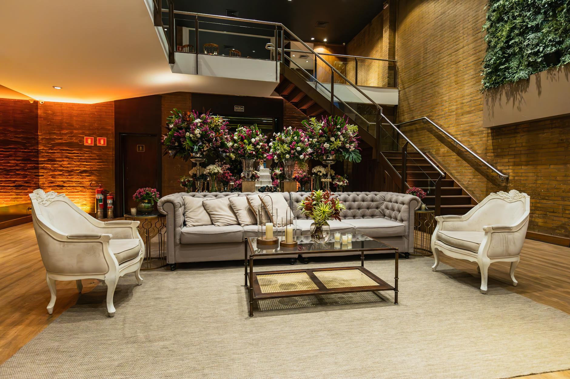 Luxurious modern living area with elegant sofas, vibrant floral arrangements, and ambient lighting.