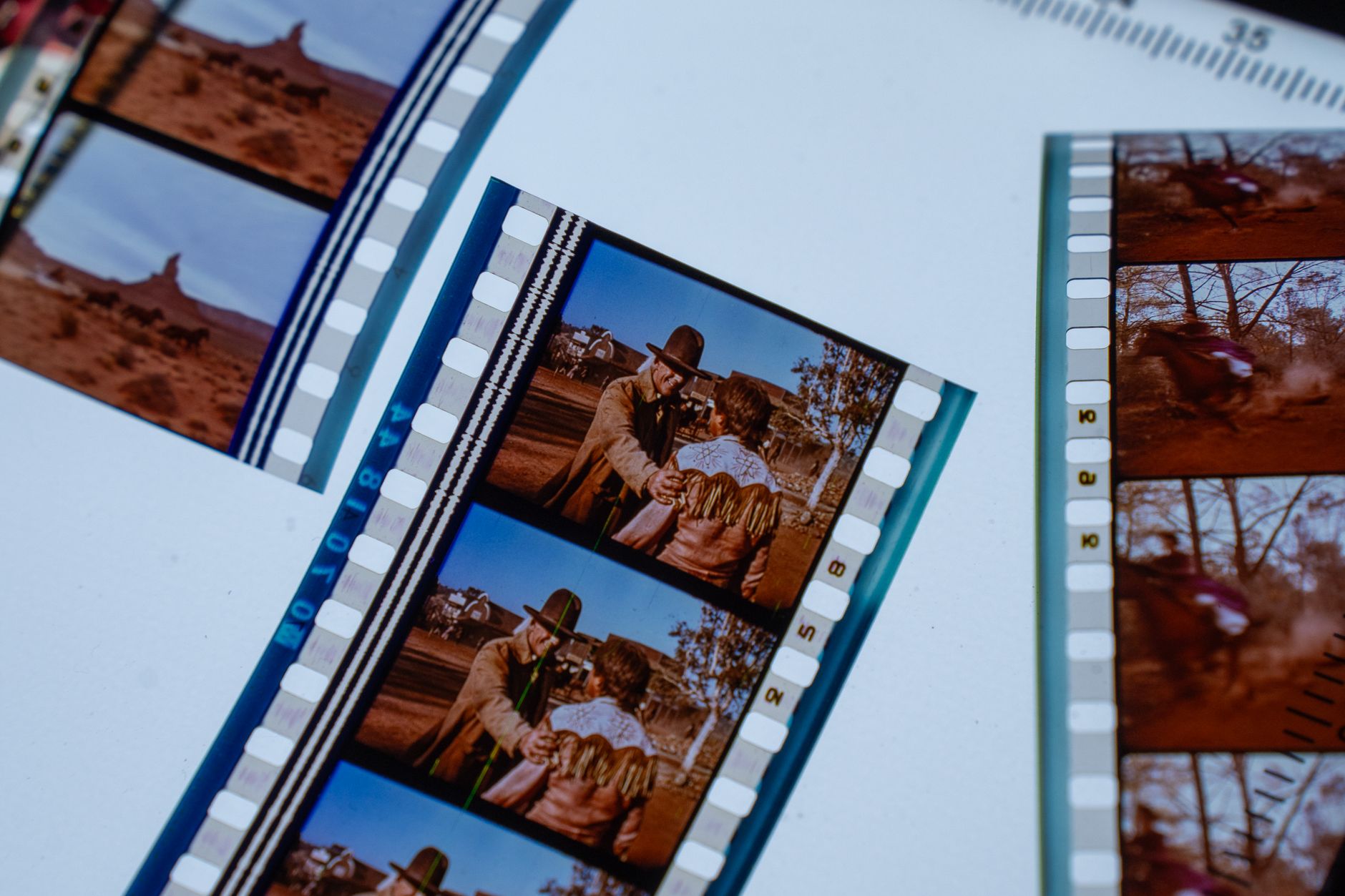 Close-up of vintage movie filmstrips showcasing scenes of a classic Western film.