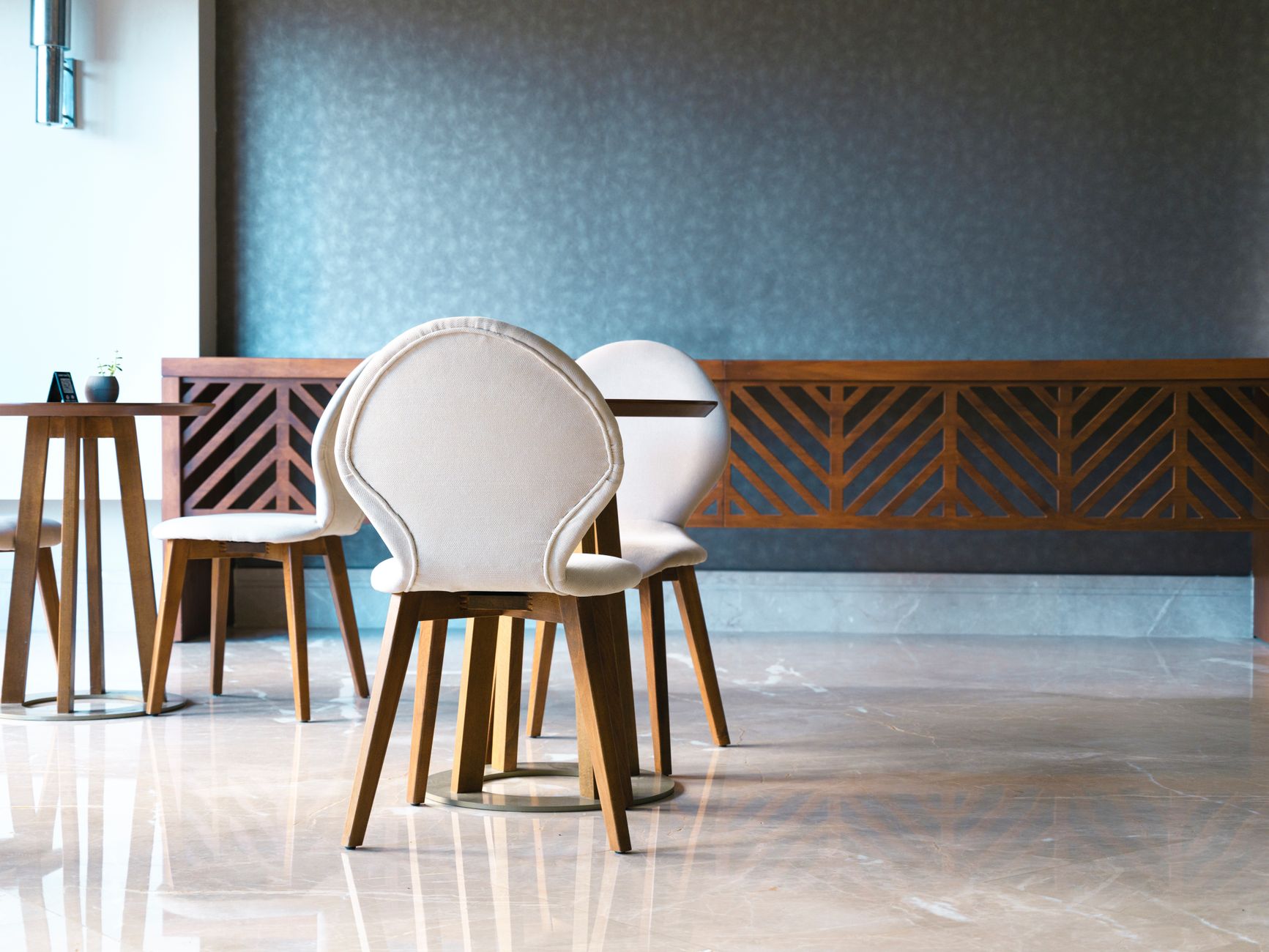 Sleek modern café interior featuring elegant wooden chairs and a minimalist design with ample copyspace.