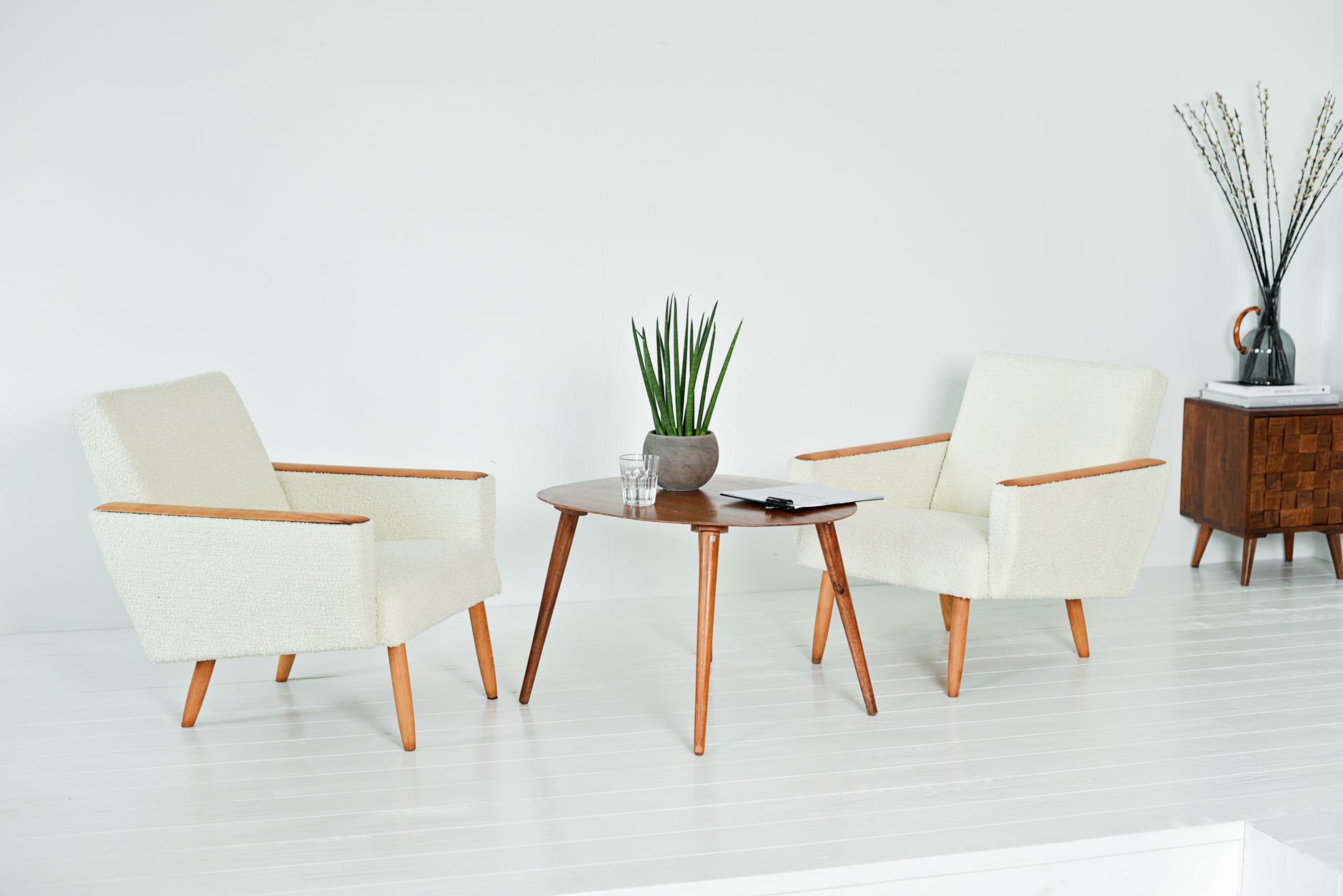 Modern living room with armchairs, table, and potted plant, elegant and stylish.