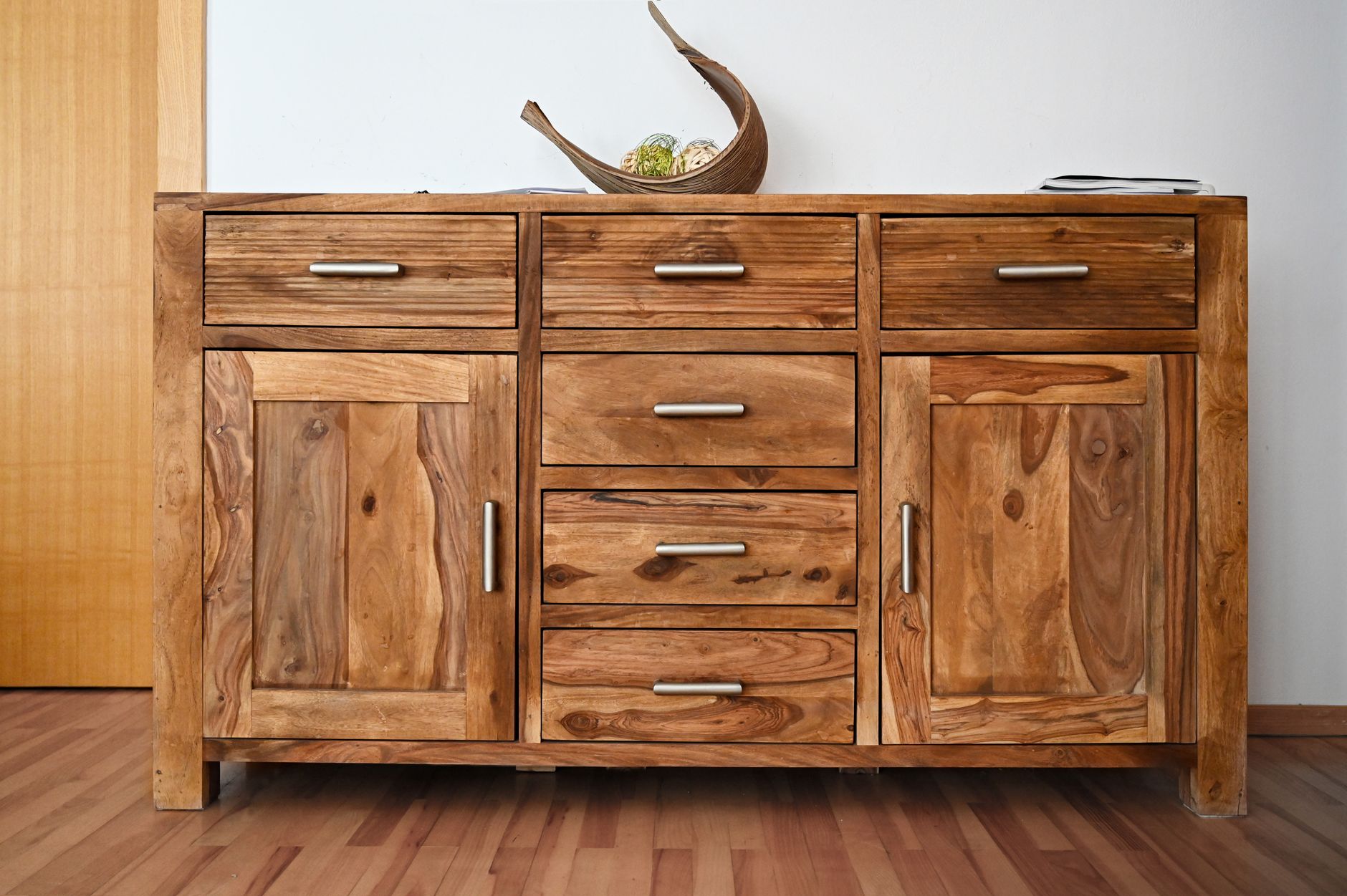 Beautiful wooden cabinet with sleek handles and natural wood grain, ideal for stylish interiors.
