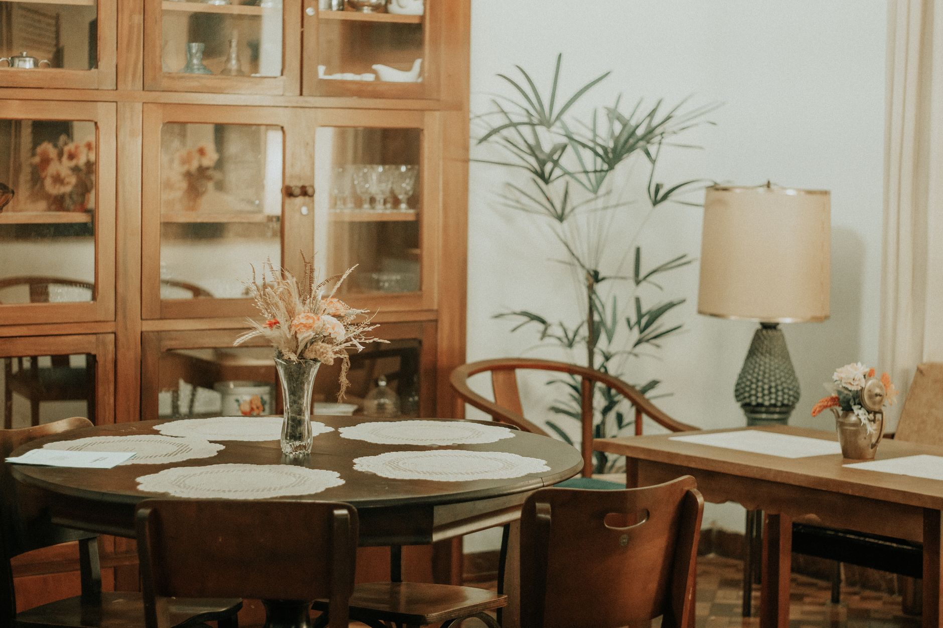 A cozy vintage living room featuring a wooden round table and classic decor elements.
